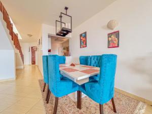モンバサにあるShabiki Sea View Apartmentsのダイニングルーム(青い椅子、テーブル付)