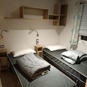 two beds in a small room withermottermottermott at Les Ch'tis Normands 2! in Litteau