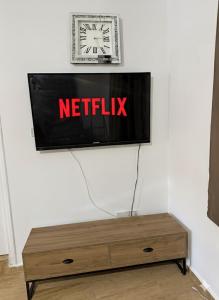 einen Fernseher an der Wand mit einer Uhr drauf in der Unterkunft Villa Keskin - Girne in Ayios Ioannis