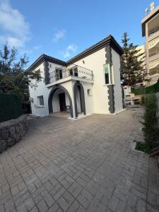 ein großes weißes Haus mit einer großen Auffahrt in der Unterkunft Villa Keskin - Girne in Ayios Ioannis + 19 Fotos