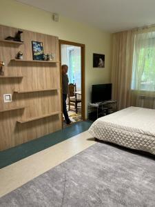 een man in een slaapkamer met een bed bij Lucia's apartment in Chişinău