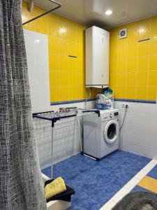 een wasruimte met een wasmachine en gele muren bij Lucia's apartment in Chişinău