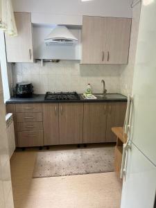een keuken met houten kasten en een kookplaat met oven bij Lucia's apartment in Chişinău +5 foto's