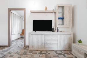 a living room with a tv on a dresser at Affittacamere Gutturu e Forru in Villacidro