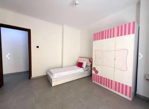 a bedroom with a bed with a pink and white wall at Charming apartment in Oran in Bir el Djir