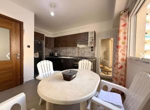 a kitchen with a table and chairs in a kitchen at Charming apartment in Oran in Bir el Djir +5 photos