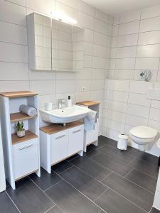 a bathroom with a sink and a toilet at Schwarzwald - Modern mit Terrasse in Schramberg