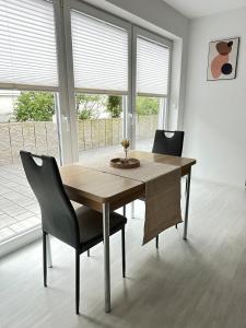 a dining room table and chairs in a room with windows at Schwarzwald - Modern mit Terrasse in Schramberg +4 photos