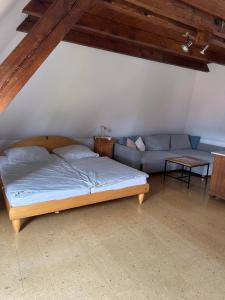 a bed and a couch in a room at Bioweingut Glaser in Hainfeld