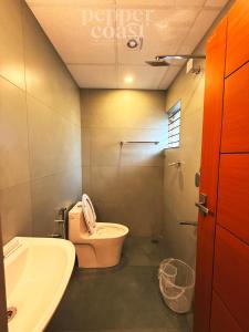 a bathroom with a toilet and a sink at Pepper Coast Luxury Business Hotel in Cochin