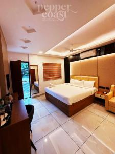 a hotel room with a bed and a desk and a desk at Pepper Coast Luxury Business Hotel in Cochin +74 photos