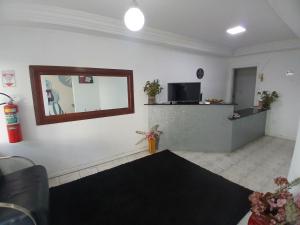 a living room with a mirror on the wall at Pousada recanto das ondas in Macaé +20 photos