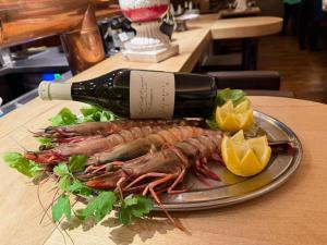 a plate with a lobster and a bottle of wine at Brauerei Gasthaus Lohhof im Münchner Norden, direkt an der S1, nähe vom Flughafen, Zentrum, A92, Allianz Arena, Ruderregatta und Schießanlage G- Hochbrück entfernt, Internationale Küche in Unterschleißheim