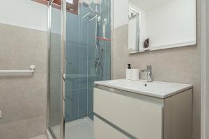 a bathroom with a glass shower and a sink at Villa Poldina in Budoni +35 photos