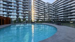 a large swimming pool in front of a large apartment building at Full of Fun shopping 1BR stay at Clayton in Clayton North
