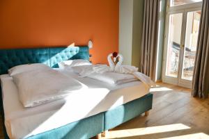 un grande letto in una camera da letto con parete arancione di Hotel Savoia a Dobbiaco