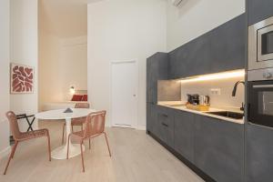 une cuisine avec une table et des chaises dans une pièce dans l'établissement Dobo Málaga Perchel, à Malaga