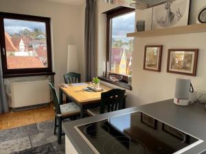 a kitchen and dining room with a table and two windows at Ruhiges Apartment in Weissach - Nähe Porsche in Weissach +4 photos