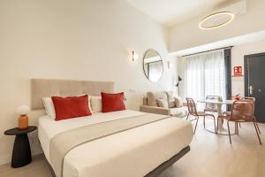 une chambre blanche avec un grand lit et une table dans l'établissement Dobo Málaga Perchel, à Malaga 11 autres photos