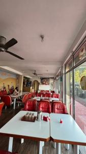 een trein-eetkamer met tafels en rode stoelen bij The Bran Saga in Haripūr