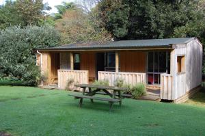 a wooden cabin with a picnic table in front of it at Egmont Eco Leisure Park & Backpackers in New Plymouth +23 photos