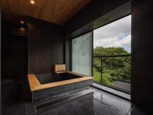 a room with a large window and a bath tub at Hakone Hibarino in Hakone