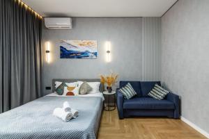 a hotel room with a bed and a blue chair at Современный отдых в сердце города in Almaty