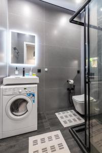 a bathroom with a washing machine and a sink at Современный отдых в сердце города in Almaty