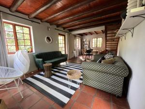 The Little Thatch Cottage في غرايتون: غرفة معيشة مع أريكتين وطاولة +صورة واحدة