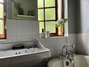 The Little Thatch Cottage في غرايتون: حمام مع حوض ومغسلة ونافذة