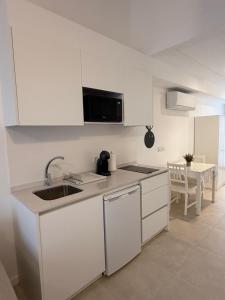 a kitchen with white cabinets and a sink and a table at K&A Apartments in Valencia +10 photos