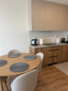 a kitchen with a wooden table with four chairs at Apartament N32 in Garwolin +11 photos