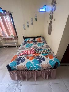 a bedroom with a bed with a colorful quilt on it at Subangan Veranda1, Burgos Central location in Burgos +23 photos