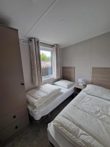 a bedroom with two beds and a window at TETchalet met wellness tuin in Berkhout +19 photos