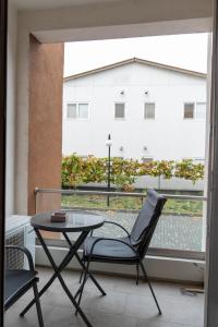 a table and chair on a balcony with a view of a building at Vanguard Suite De Lux in Craiova