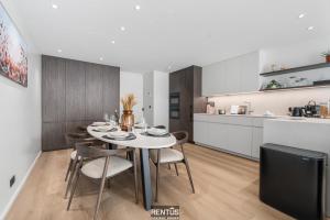 een eetkamer met een tafel en stoelen en een keuken bij Newport 3 - luxury apartment with side sea view in Nieuwpoort