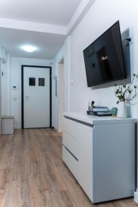 a living room with a flat screen tv on a white wall at Vanguard Suite De Lux in Craiova