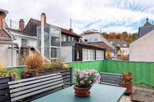 a patio with a green fence and a table with flowers at Haus Stiegeler - Gottfried Beck in Freiburg im Breisgau