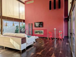 ein Wohnzimmer mit einer roten Wand in der Unterkunft Villa a 100 metros de la playa in Castellón de la Plana + 14 Fotos