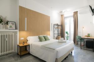 ローマにあるLilla Suites - Musei Vaticaniの大きな白いベッドと机のある寝室