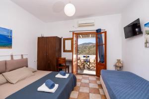 a bedroom with two beds and a door to a balcony at Motivo in Kastron