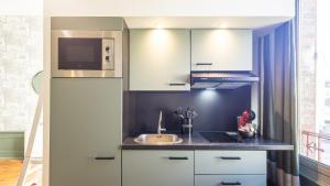 Una pequeña cocina con fregadero y microondas. en BonAppart 13 - Charme Napoléonien & Confort, en Troyes 11 fotos más