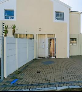 a white house with a gate and a fence at 2 Bed, King XL Bed, Dining&Office Space in Heathfield