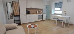 a living room with a table and a kitchen at kreuzwirt bayern in Essenbach +38 photos