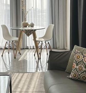 ein Wohnzimmer mit Tisch, Stühlen und Sofa in der Unterkunft Tashkent City Downtown Deluxe Host Apartments in Taschkent