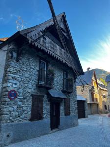 een stenen gebouw met 2 ramen en een balkon bij SNÖ Casa Pucurull in Salardú