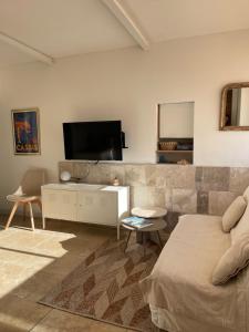 ein Wohnzimmer mit einem Bett und einem Flachbildfernseher in der Unterkunft Appart Bianca T2 - Terrasse - Parking - Calme - 1mn de la mer in Cassis