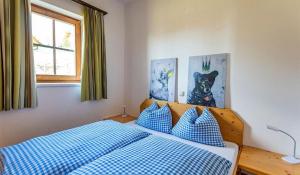 霍赫林德Kernmayerhütte的卧室里有一张床，上面有蓝白色的枕头