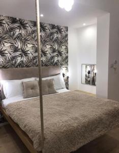 a bedroom with a large bed with a large headboard at Idromasage room in Catania +2 photos