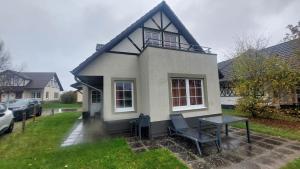 ein kleines weißes Haus mit einem Tisch und Stühlen in der Unterkunft Haus am Golfplatz Cochem Mosel in Ediger-Eller